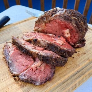 smoked ribeye roast sliced on a cutting board