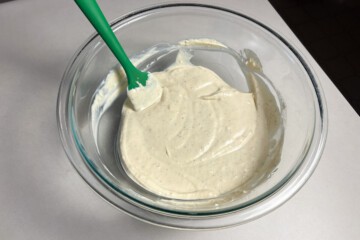 horseradish cream sauce mixed in a glass bowl with a small silicone spatula