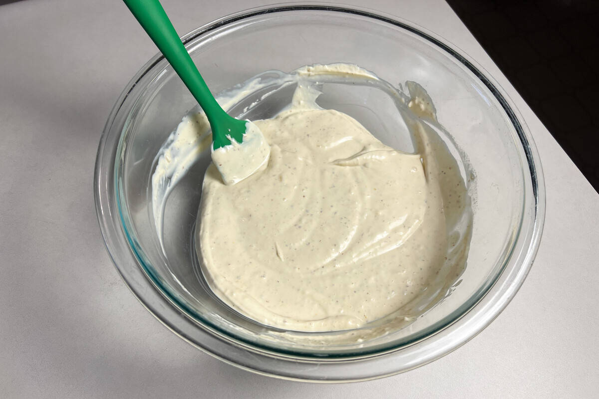 horseradish cream sauce mixed in a glass bowl with a small silicone spatula