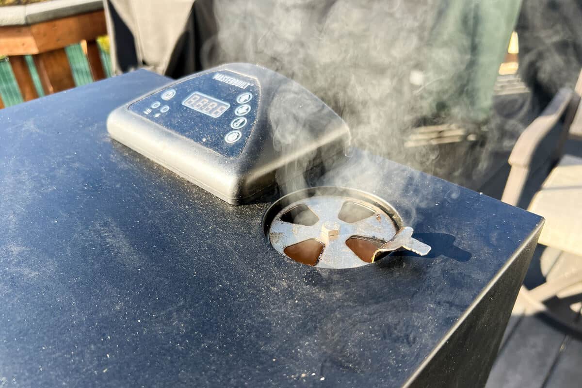 smoke coming out of the top vent of a Masterbuilt electric smoker