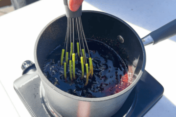 stirring a red wine au jus in a pan