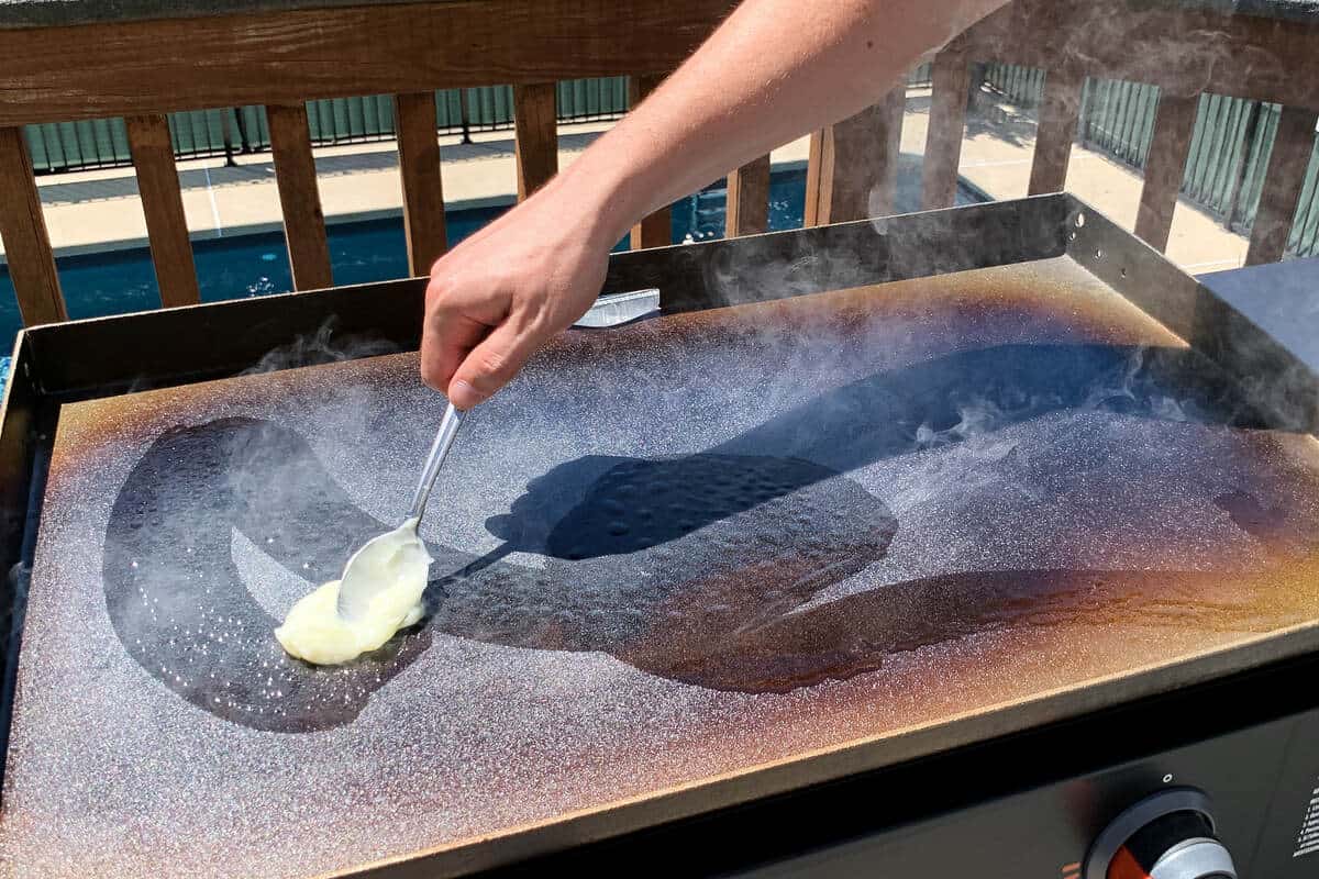 conditioning oil on the surface of a hot, smoking Blackstone griddle