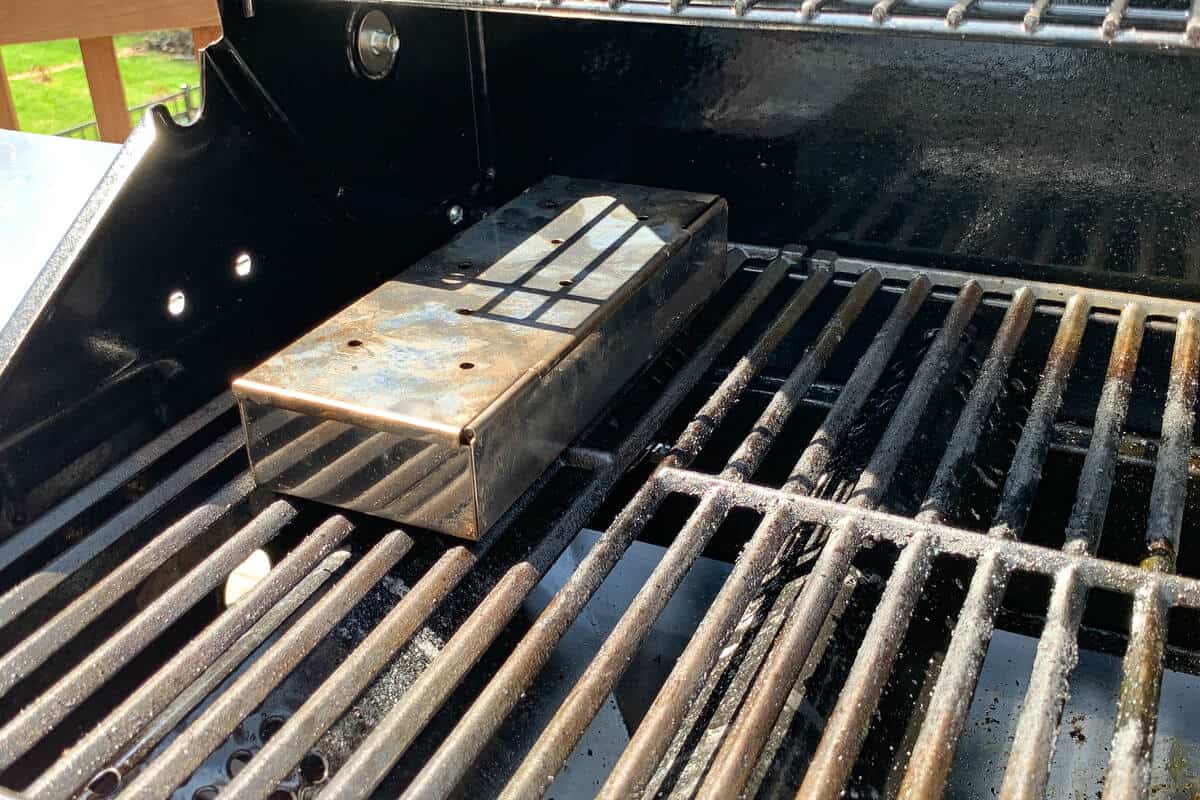 a smoker box on the grates of a gas grill