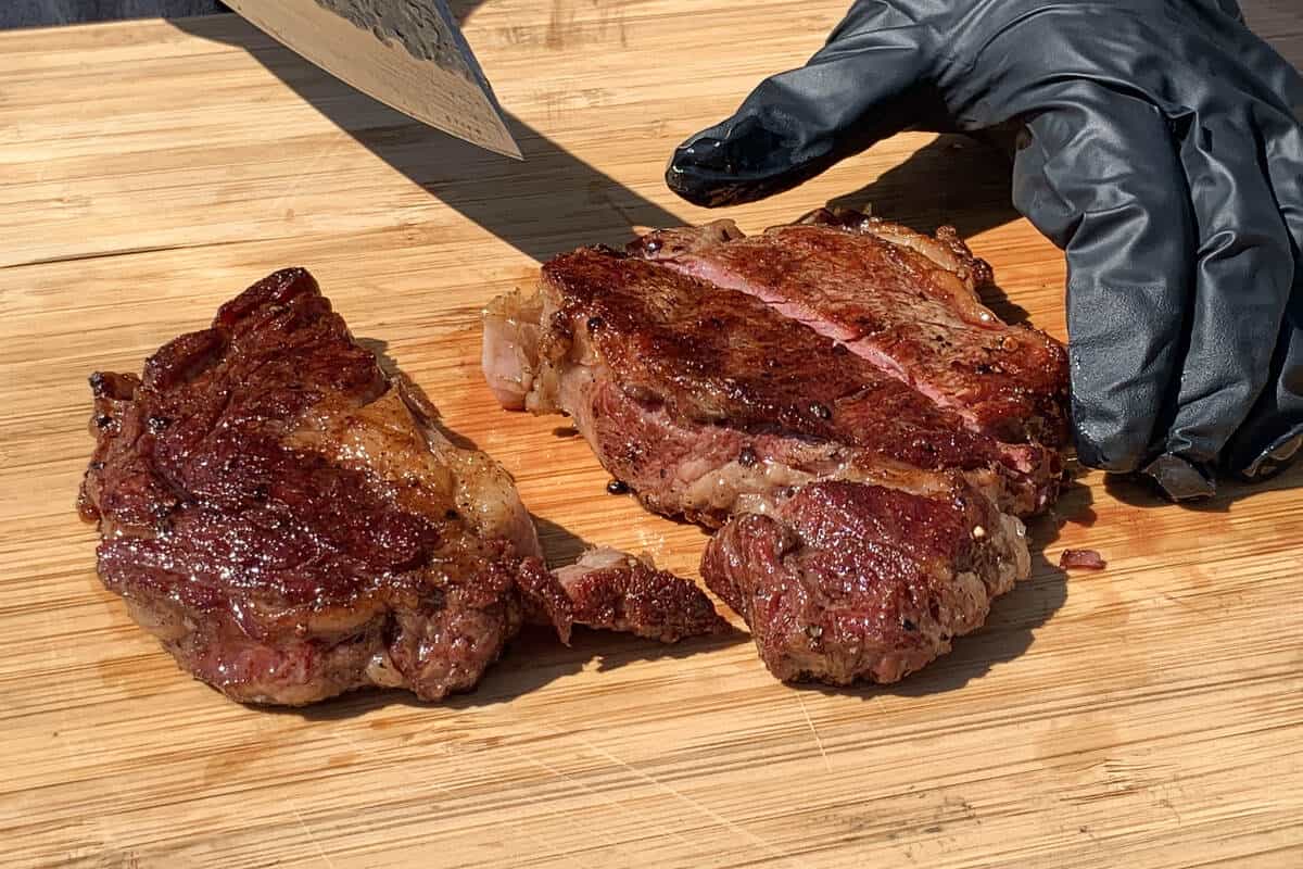 steak being sliced with a knife on a cutting board