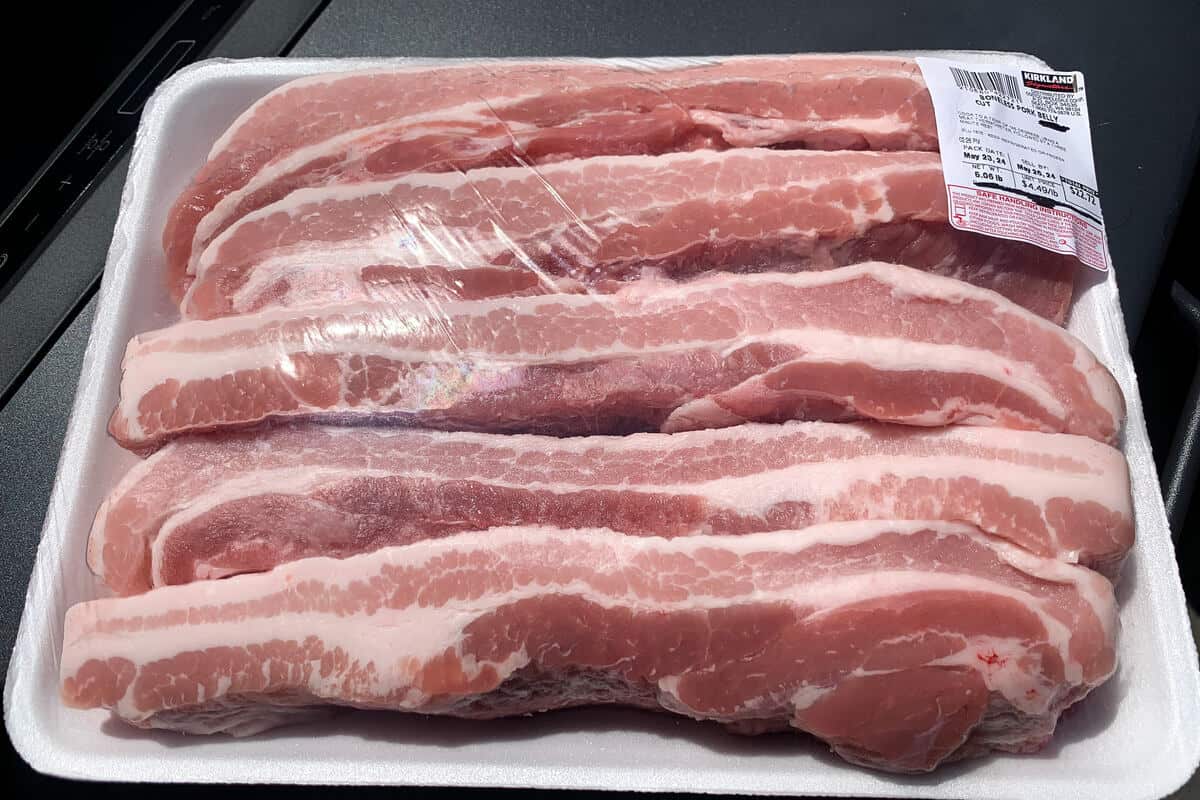 a sealed package of raw pork belly strips