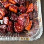 pork belly burnt ends in an aluminum foil pan