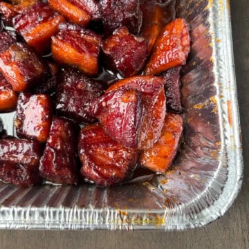 pork belly burnt ends in an aluminum foil pan