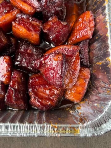 pork belly burnt ends in an aluminum foil pan