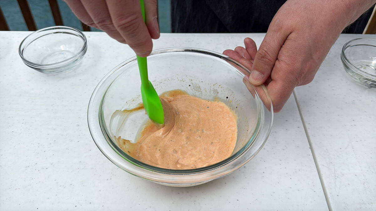 burger sauce in a glass bowl being stirred with a silicone spatula