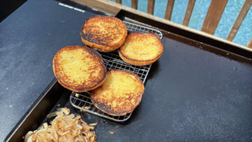 toasted hamburger buns staying warm on a wire rack