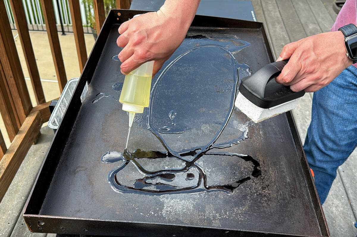 a Blackstone griddle with oil being poured on it