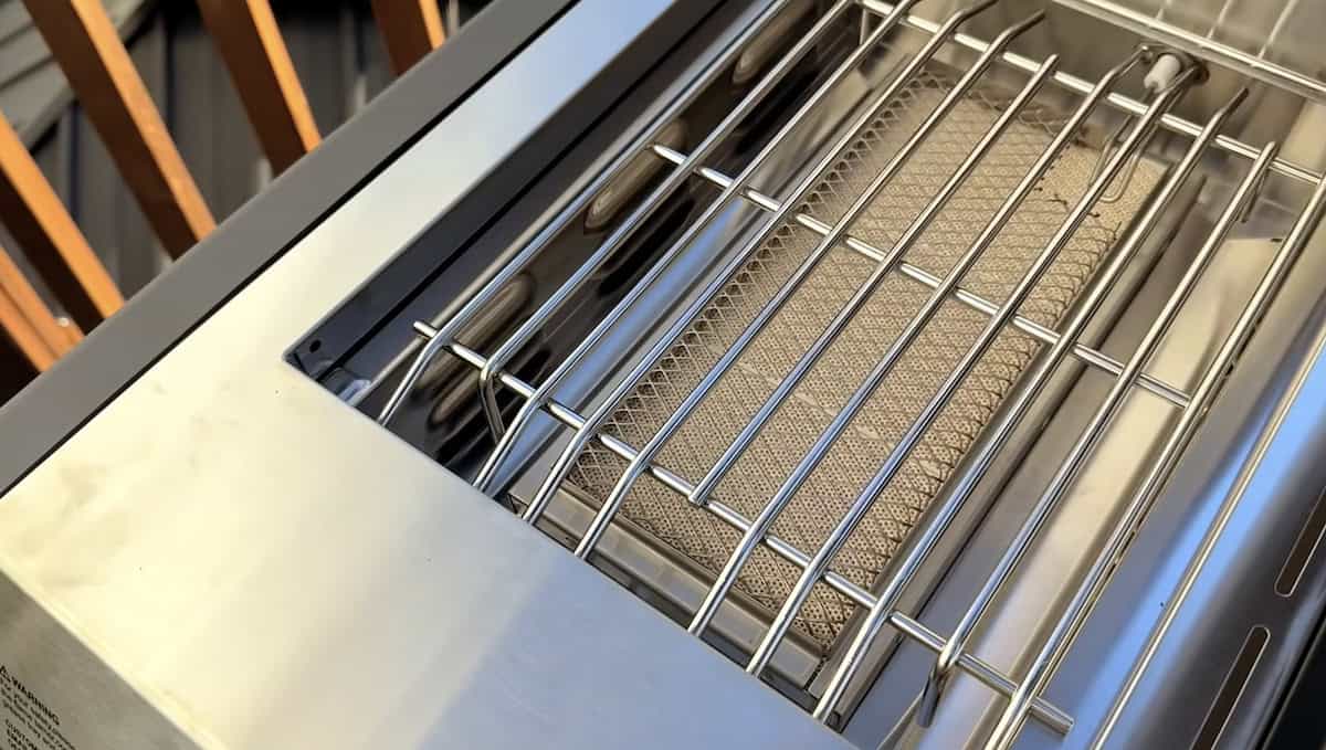 Stainless steel outdoor grill with cooking grates and side burner for backyard cooking.