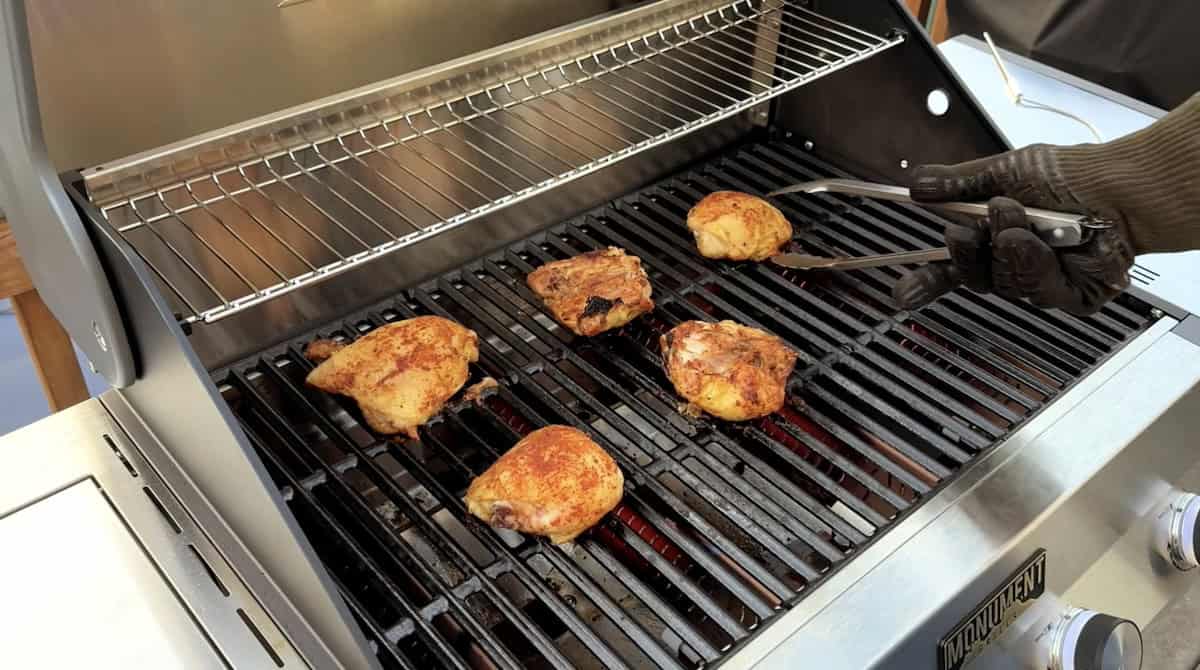 Cooking chicken thighs on a barbecue grill for flavorful outdoor grilling.