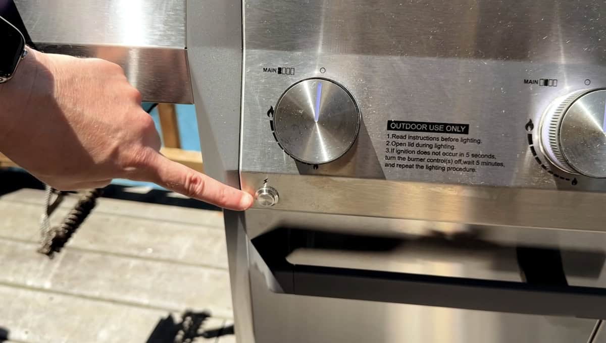 Outdoor grill control panel with temperature knob and ignition button.